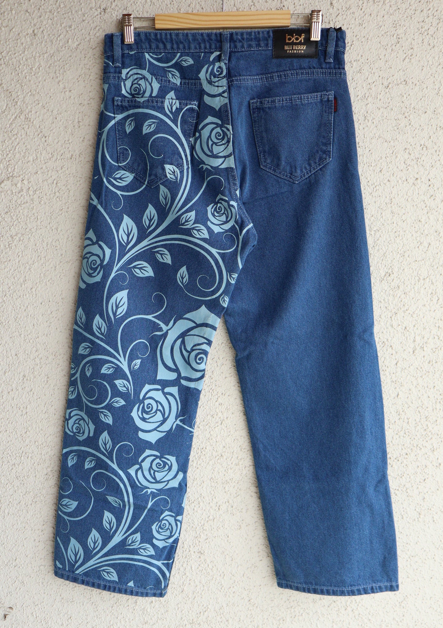 Blue jeans with floral pattern on a light gray background